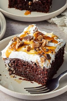 a piece of cake on a plate with a fork in front of it and two plates behind it