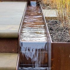 water flowing down the side of a metal planter