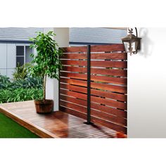 a wooden fence next to a potted plant on top of a grass covered deck