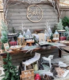 an outdoor display with christmas decorations and trees on the side of a wooden building that says baby