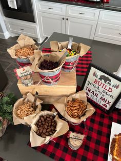 a table topped with baskets filled with nuts and crackers on top of a red checkered table cloth