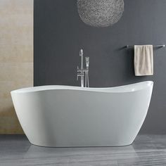 a white bath tub sitting in a bathroom next to a wall mounted faucet