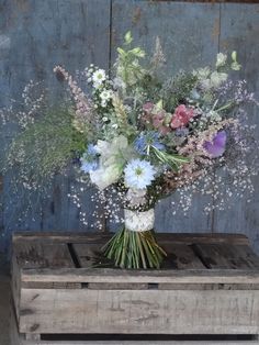 a bouquet of flowers sitting on top of a wooden box