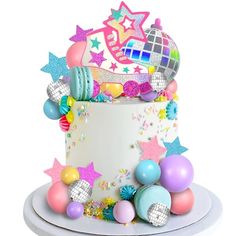 a birthday cake decorated with stars and disco ball decorations on a white plated platter