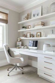 a white desk and chair in a room with shelves on the wall above it, along with bookshelves