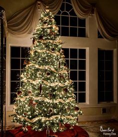 a decorated christmas tree in front of a window