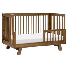 a wooden crib with white sheets on the bottom and side rails, against a white background