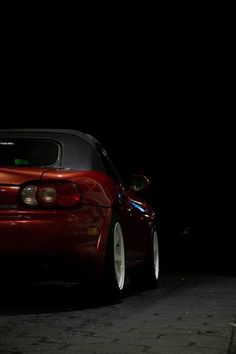 a red sports car parked in the dark