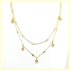 This beautiful necklace has a unique design - a very long chain that can be worn long or doubled, with the help of a toggle closure. It features tulip-shaped crystal drops set along half of the chain. Made of durable and beautiful 14kt gold-plated brass and enhanced with the finest European crystals. The full length is 42" or 20" when doubled. Made in the USA by La Vie Parisienne Gold Dangle Jewelry With Double Chain, Elegant Dangle Double Chain Jewelry, Elegant Layered Dangle Chain Necklace, Gold Crystal Backdrop Necklace For Formal Occasions, Formal Gold Crystal Backdrop Necklace, Gold Dangle Crystal Necklaces, Gold Crystal Lariat Necklace, Gold Plated Long Drop Necklace, Gold Crystal Drop Necklace