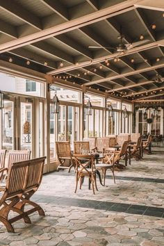 an empty restaurant with wooden chairs and tables