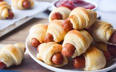 hot dogs wrapped in croissants on a plate