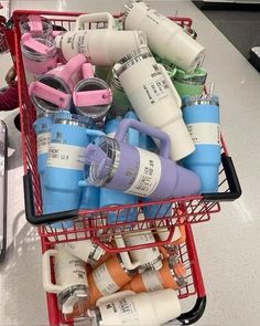 a shopping cart filled with lots of different colored cups and mugs on top of each other