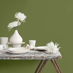 a table topped with white dishes and vases