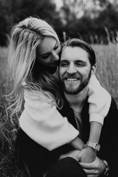 black and white photograph of a man hugging a woman on the cheek in a field