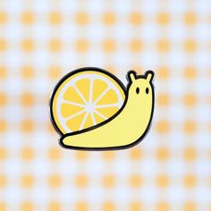 a yellow sticker with a banana and orange slice on it's side, in front of a checkered background