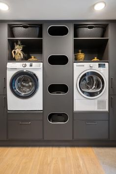 a washer and dryer in a room with wooden floors, built - in shelving