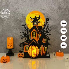 a paper cut out of a halloween house with pumpkins and jack - o'- lanterns