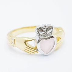 The perfect gift for yourself or someone close. Sterling silver claddagh ring set with milky pink heart shaped stone framed with white cubic zirconia in the cuffs. The hands represent friendship, the heart love and the crown stands for loyalty. This ring has been coated in a durable layer of 18k yellow gold, to maintain the color as long as possible please avoid contact with chemicals, lotions etc and keep in an airtight zip lock bag when not being worn. ----------------------------------------- Classic Pink Jewelry For Promise, Pink Hallmarked Jewelry For Valentine's Day, Promise Jewelry With Heart Cut And Polished Finish, Polished Heart Cut Promise Jewelry, Heart Cut Polished Jewelry For Promise, Heart Cut Jewelry With Polished Finish For Promise, Heart Cut Promise Jewelry With Polished Finish, Pink Hallmarked Jewelry For Anniversary, Pink Rings With Polished Finish For Gift