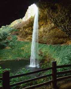 a waterfall is coming out of the side of a cave