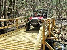 a person riding an atv across a wooden bridge