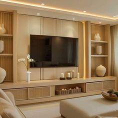 a living room filled with furniture and a flat screen tv mounted on a wall above a fireplace