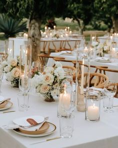 the table is set with white flowers and candles