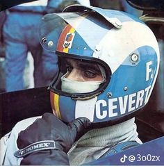 a man sitting in a racing car wearing a blue and white helmet with the word cevertt on it