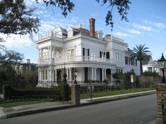 a large white house sitting on the side of a road