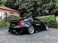 a black sports car parked in front of a house