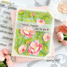 a card with flowers on it next to some other cards and paper doillies