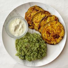 a white plate topped with rice and veggies next to a bowl of ranch dressing