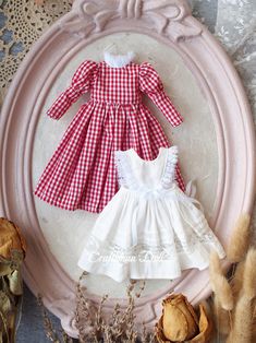 two dresses are sitting on a plate next to dried flowers