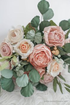 a bouquet of flowers sitting on top of a white blanket