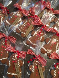 some cookies are wrapped in plastic and have red bows on the top one is shaped like gingerbreads