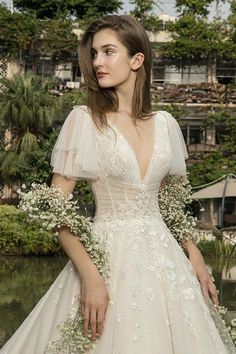 a woman in a wedding dress with flowers on her shoulder