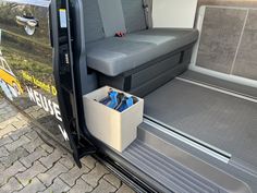 the interior of a van with its door open and storage boxes in the side compartment