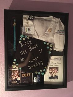 an assortment of items is displayed in a shadow box on the wall, including a t - shirt and brochure