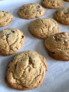 chocolate chip cookies are lined up on a baking sheet