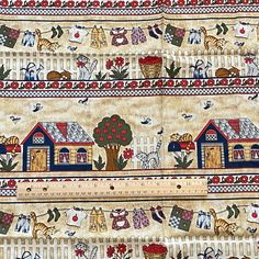 a close up of a piece of cloth with houses on it and trees, flowers, birds, cats