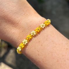 The perfect summer accessory - this cute yellow and gold flower beaded bracelet. You can even size up to style as an anklet! the perfect gift or treat for yourself. Explore more beaded bracelets and accessories at Dainty and Shine ✨  Size and details: Measuring 16cm with a 4.5cm extender chain, it offers a perfect fit for any wrist.  11/0 seed beads, and gold plated stainless steel clasp. Care instructions:  To keep it looking its best, gently wipe the bracelet with a soft cloth after wear to remove any oils or dirt. Avoid exposing it to water, perfumes, or lotions to maintain its delicate beauty over time. Spring Gold Beaded Bracelets With Colorful Beads, Handmade Gold Bracelets For Spring, Summer Bracelets With Tiny Beads, Summer Gold Friendship Bracelets With Colorful Beads, Gold Bracelets With Gold Beads For Summer, Handmade Summer Beaded Bracelets, Yellow Bracelets With Tiny Beads For Friendship, Spring Gold Bracelets With Round Beads, Yellow Friendship Bracelets With Tiny Beads