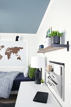 a bed room with a neatly made bed and a world map on the wall above it