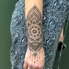 a woman's hand with a tattoo on it and a flower in the middle