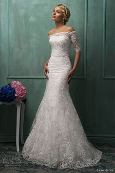 a woman in a white wedding dress standing next to a table with flowers on it