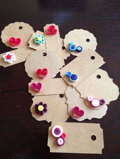 several pieces of crafting paper with buttons on them sitting on top of a table