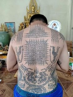 the back of a man with tattoos on his body