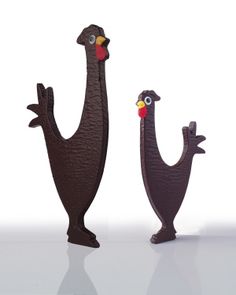 two metal figurines are standing next to each other on a white surface, one is wearing a turkey hat and the other has a red nose