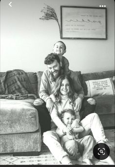 a black and white photo of a family sitting on the floor in their living room