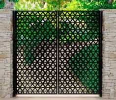 an iron gate with stone walls and trees in the background