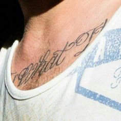 a close up of a man's neck with writing on the back of his chest