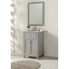 a bathroom vanity with a mirror above it and a rug on the floor next to it